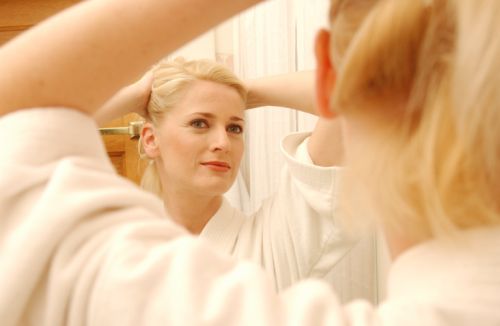 Woman looking into mirror