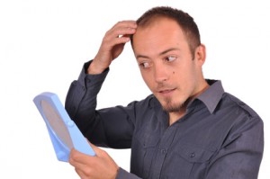 Man checking his hair loss in the mirror